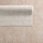 Overhead view of rug with corner partially rolled, showing front pattern and textured backing