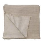 Folded Vancouver Coverlet showing reversible design with different quilted patterns on each side in beige tones