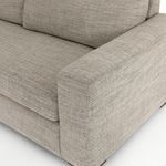 Close-up on right armrest and seat cushion corner showing upholstery stitching