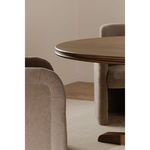 Close-up of Charles dining table and beige upholstered chairs in softly lit room.