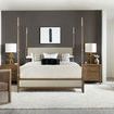 Front view of Chapman bed in styled bedroom with taupe bedding, wooden nightstands, lamps, and wall art on dark gray wall