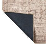 Corner of rug flipped to show black non-slip backing detail with stitched edges
