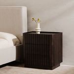 Partial side view of Ichigo bed headboard alongside dark wooden plinth nightstand with vase