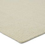 Close-up of ribbed wool texture and edge binding in cream color