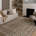 Wade Brown Stone Rug styled in living room with neutral sofa, modern fireplace, and wood flooring