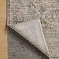 Ida Slate rug corner partially lifted to reveal light beige underside and a gray rug pad underneath on wood floor