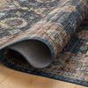 Folded rug edge curling on wooden floor reveals backside texture and thin profile