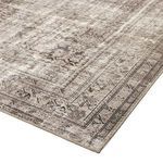 Angled view highlighting rug's flat weave and slightly worn vintage-style floral border