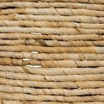 Close-up of textured handwoven corn rope strands forming the table surface and side