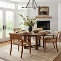 Rivers Natural Ivory Rug shown under a dining table in a bright room with wooden chairs and a fireplace