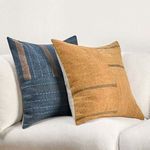 Blue patchwork pillow alongside a mustard yellow patchwork pillow on white sofa