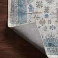 Corner of the rug slightly flipped showing non-slip backing and tightly bound edges