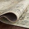 Side view of rug partially rolled to showcase thin profile and flexible construction