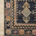 Close-up of rug corner showing intricate border designs and flat woven texture on light wood floor