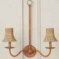 Double arm chandelier with natural woven Bell shades mounted on white wall with decorative molding