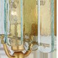 Close-up of textured glass panels and gold leaf finish with visible lightbulb