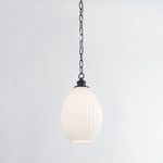 Pendant light illuminated casting soft warm glow through fluted glass shade