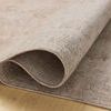 Rolled corner of the rug showing its soft, velvety polyester pile and underside weave on a light wood floor