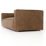 Close-up side view of Nolita Reverse Stitch Sofa showing smooth leather and boxy armrest from a low angle.