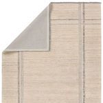 Top view of rug corner folded over revealing plain gray backing