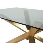 Close-up of Couture Dining Table’s gold metal base joint and underside of clear glass top