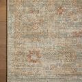 Close-up detail of corner edge on wooden floor highlighting faded aqua and terracotta woven patterns