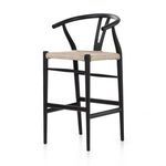 Three-quarter front view emphasizing the flowing teak curves and woven seat texture
