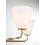 Close-up on swirling strie glass shade and warm brass arm of Blair chandelier