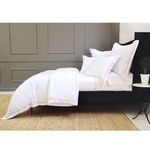 Side angle of duvet set showing pink piping detail and slightly folded top section on black bed frame