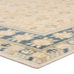 Low angle corner close-up of the rug showing thickness and detailed pattern of the organic floral border