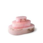 Stacked three pink alabaster oval boxes of different sizes highlighting color variation and veining