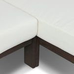 Close-up detail of chaise joint where white cushions meet with dark wood base