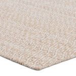 Close-up angled view highlighting soft texture and woven fibers of the tan and cream trellis rug