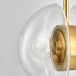 Extreme close-up of clear hemisphere and bulb filament visible inside aged brass fixture