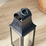 Close-up of top part of lantern showing metal loop handle and curved powder-coated black steel roof