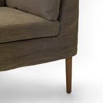 Close-up of the amber oak tapered wood leg and upholstery seam details
