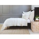 Side view of bed with Vancouver Sham styled with matching bedding and a stone bedside table with plant