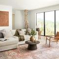 Loren rug covering floor beneath large white sectional and modern chairs in sunlit living area