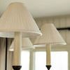 Three chandelier shades shown in warm indoor lighting with window in background