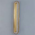 Vertical wall sconce with aged brass center bar installed on light blue wall