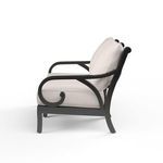 Side view showing the scroll detail on the armrests and the profile of the thick cream cushions