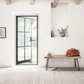 Bellamy Sky Rug displayed in a bright entryway with wooden bench, open black-framed door, and white walls with exposed beams