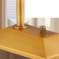Close-up of brushed brass square base featuring ridged control knob and lamp stem