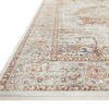 Low side angle view highlighting the border and fringe detailing of the ivory and sunset toned rug