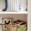 Ellie Glass Jar placed near framed abstract art and woven baskets on a white shelf