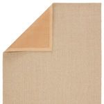 Top corner folded back revealing smooth, tan rubber backing and rug’s woven chevron texture