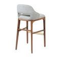 Back angled view of Inga Stool showing upholstery cutout and tapered wood legs