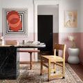 Wynter rug in a study room with black marble desk, wooden chair, and pink and white walls