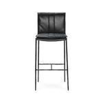 Mayer Stool with thin iron legs and black leather seat featuring rolled back and decorative stitching