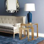 Plano Side Tables with blue lamp and mirror in background beside beige tufted sofa on blue rug